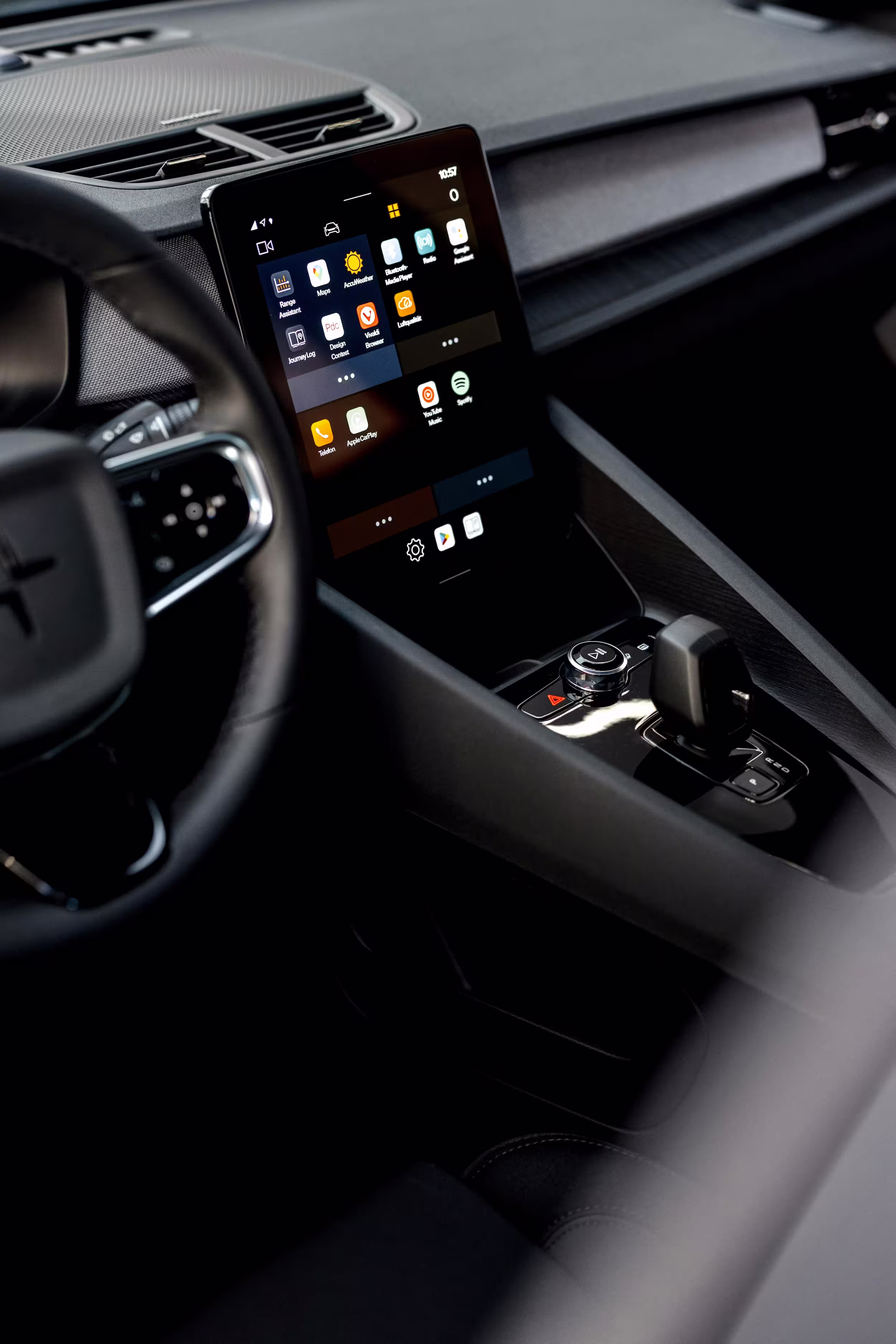 Close-up of a car interior displaying a digital touchscreen infotainment system and control knob on the center console.